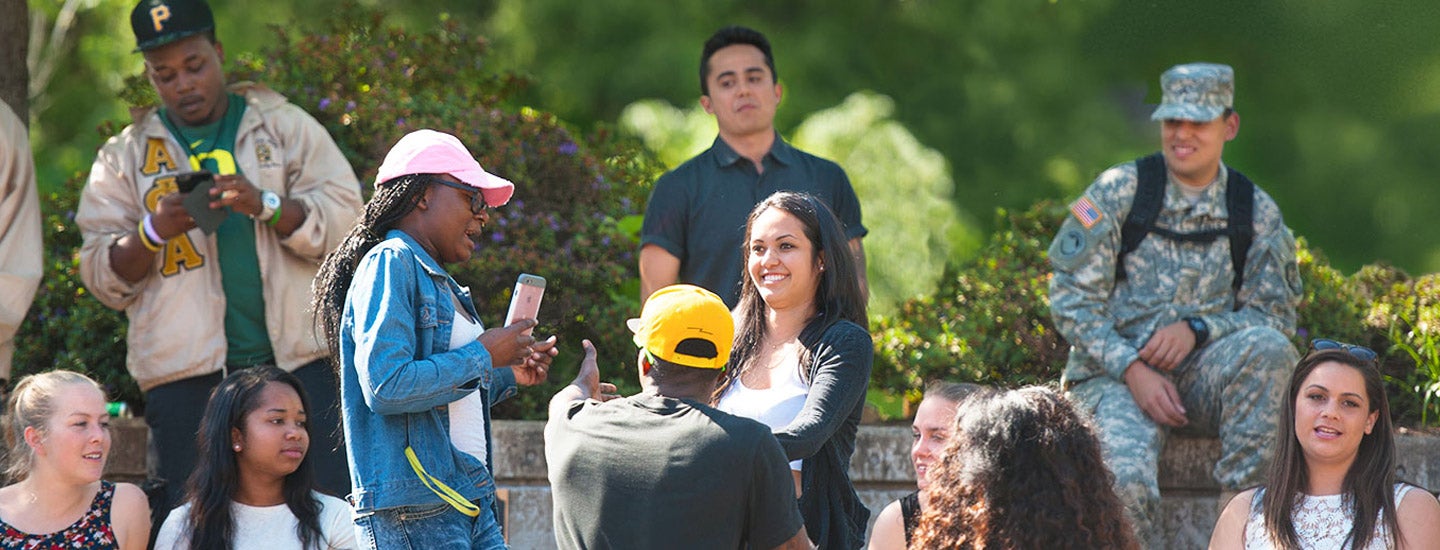 A diverse group of students hang out together in the Erb Memorial Union amphitheater.